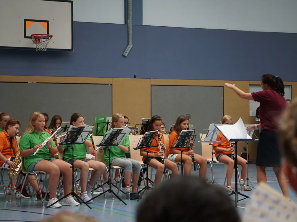Dirigentin leitet das Schulorchester.